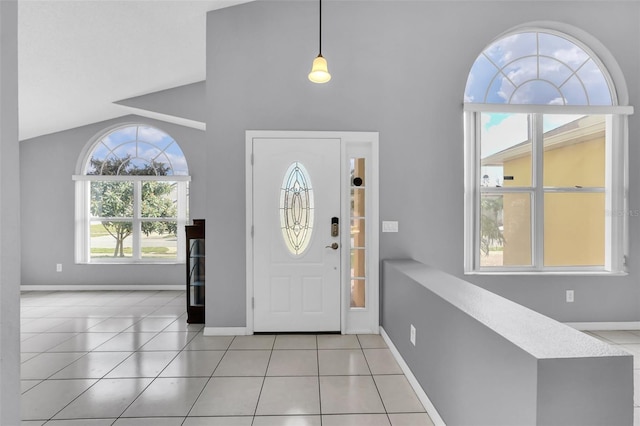 foyer entrance featuring light tile patterned flooring and high vaulted ceiling