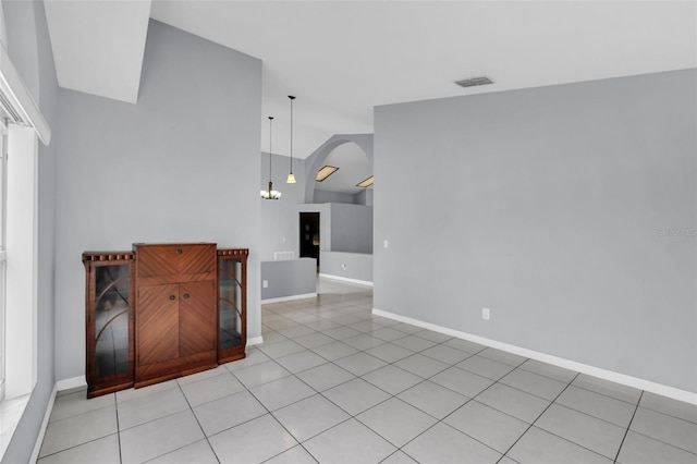 tiled living room with a chandelier and vaulted ceiling