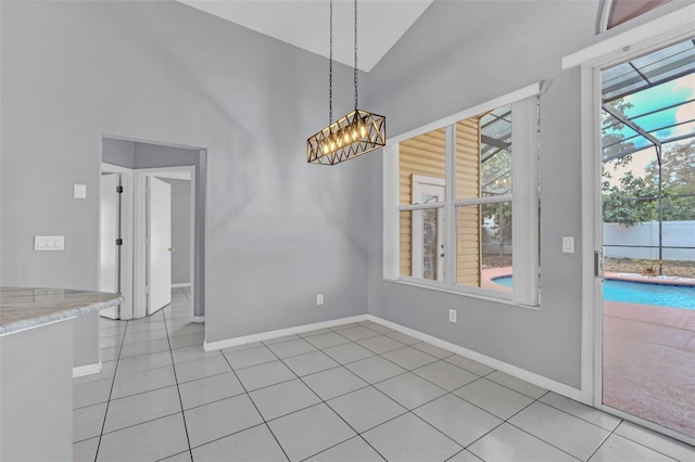 unfurnished dining area with an inviting chandelier, a high ceiling, and light tile patterned flooring