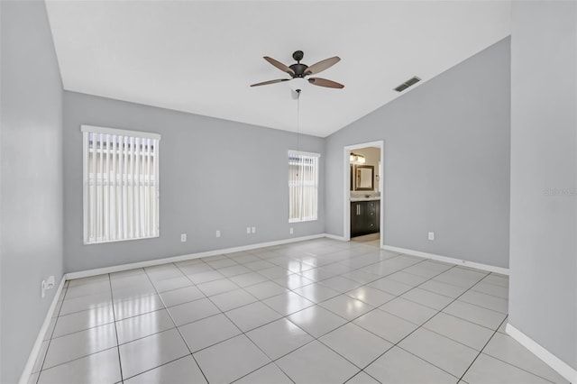 tiled empty room featuring lofted ceiling and ceiling fan