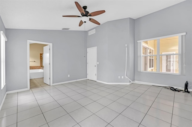 tiled spare room with vaulted ceiling and ceiling fan