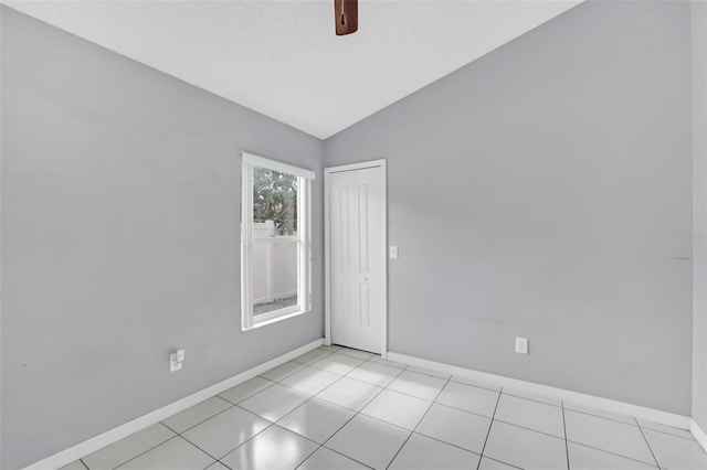 spare room with light tile patterned flooring, lofted ceiling, and ceiling fan