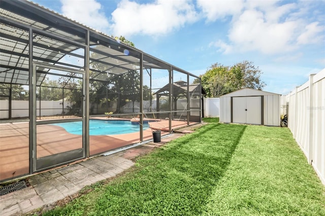 view of pool with a patio, a lanai, a yard, and a storage shed