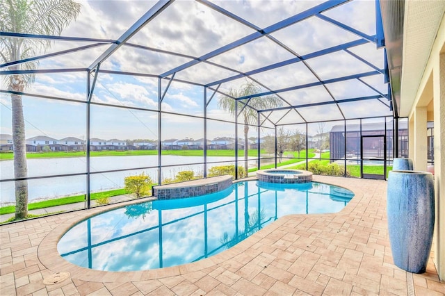 view of pool featuring an in ground hot tub, a water view, glass enclosure, and a patio area