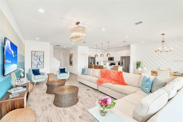 living room with an inviting chandelier and light hardwood / wood-style floors