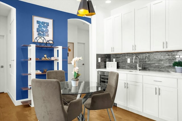 dining area featuring wet bar, dark hardwood / wood-style floors, and beverage cooler