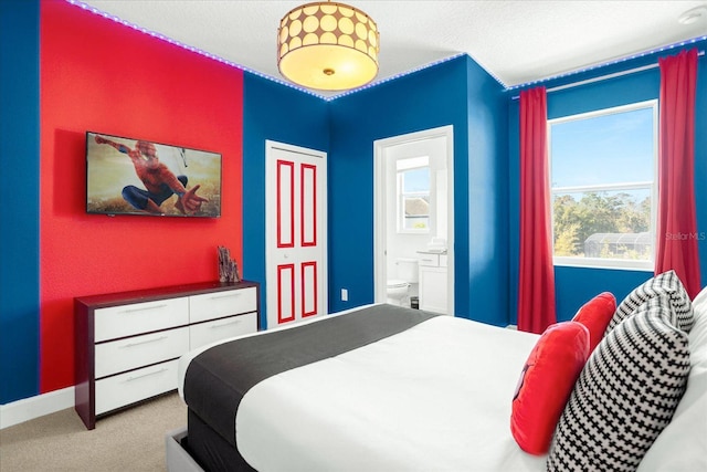 bedroom featuring multiple windows, ensuite bathroom, and carpet flooring