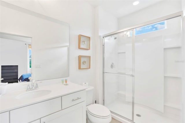 bathroom with vanity, toilet, and a shower with door