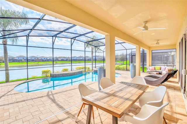 view of swimming pool featuring a lanai, ceiling fan, a water view, a patio area, and an outdoor hangout area