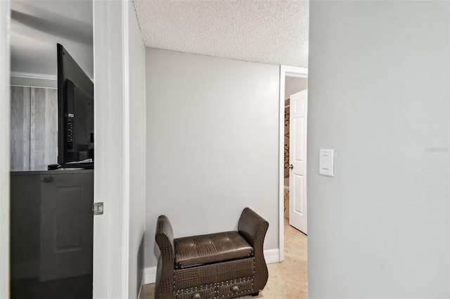 hallway featuring light tile patterned flooring and a textured ceiling