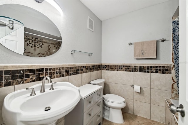 bathroom with sink, tile walls, tile patterned floors, and toilet