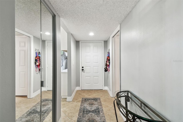 corridor featuring a textured ceiling and light tile patterned flooring