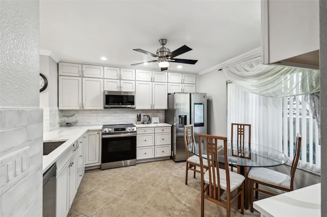 kitchen featuring crown molding, backsplash, appliances with stainless steel finishes, ceiling fan, and white cabinets