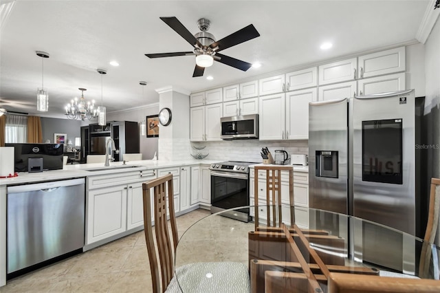 kitchen with sink, appliances with stainless steel finishes, white cabinetry, ornamental molding, and decorative backsplash