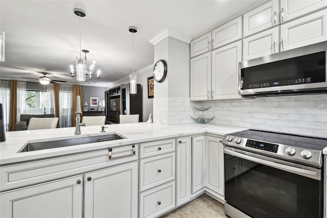 kitchen with pendant lighting, appliances with stainless steel finishes, white cabinetry, ornamental molding, and kitchen peninsula