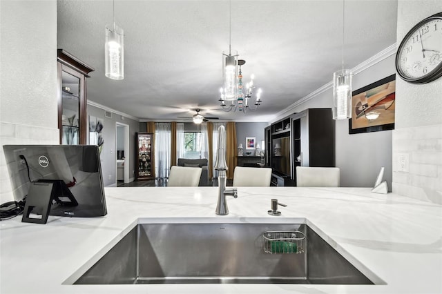 kitchen with crown molding, hanging light fixtures, and a textured ceiling