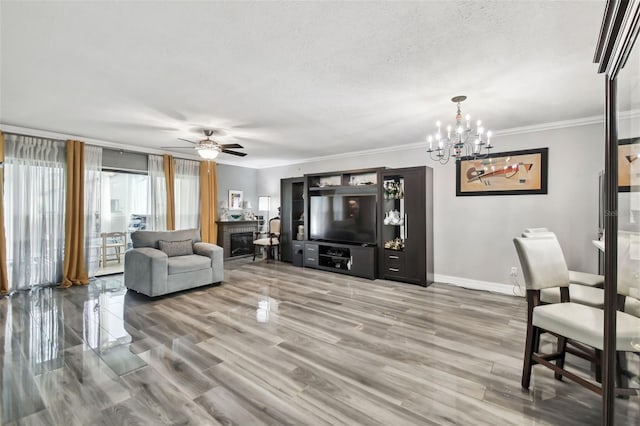 living room with crown molding, hardwood / wood-style floors, ceiling fan with notable chandelier, and a textured ceiling