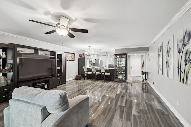 living room featuring dark hardwood / wood-style flooring, crown molding, and ceiling fan with notable chandelier