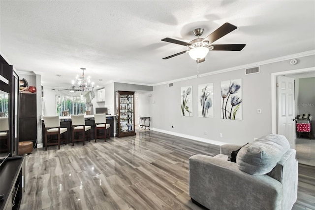 living room featuring hardwood / wood-style flooring, ornamental molding, and a textured ceiling