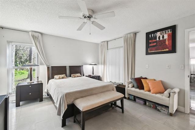 tiled bedroom featuring ceiling fan and a textured ceiling