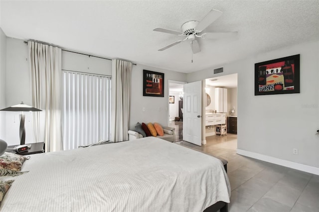 bedroom featuring ceiling fan, ensuite bath, and a textured ceiling