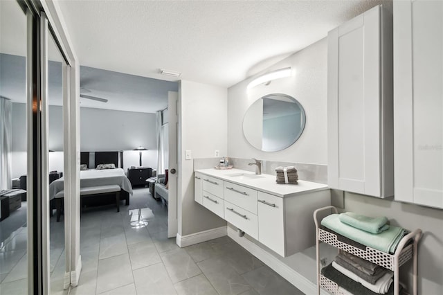 bathroom with tile patterned flooring, vanity, and a textured ceiling