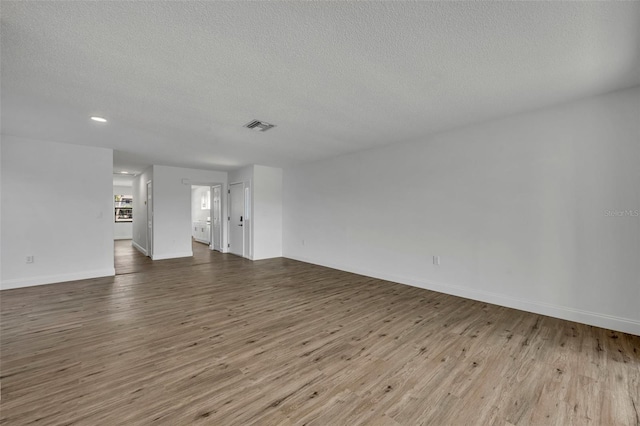 unfurnished living room with a textured ceiling and light wood-type flooring