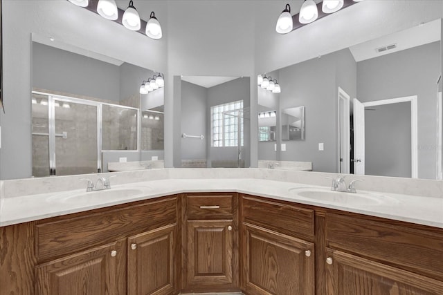 bathroom with vanity and a shower with door