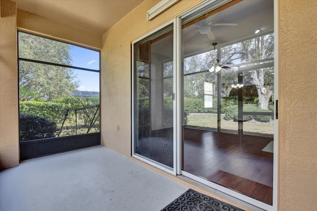 unfurnished sunroom with ceiling fan