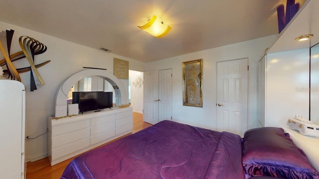 bedroom featuring light hardwood / wood-style floors and white fridge