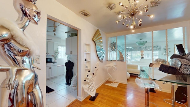 bedroom with a notable chandelier and light wood-type flooring