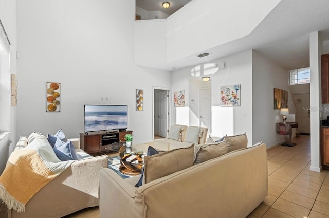 living room featuring light tile patterned floors and a high ceiling