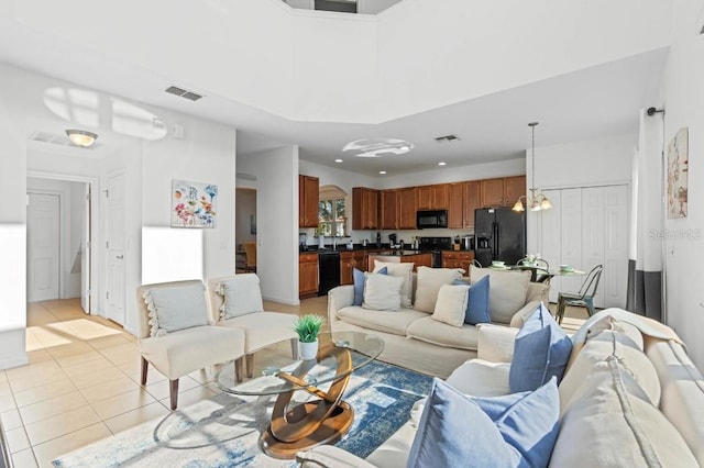 tiled living room featuring an inviting chandelier