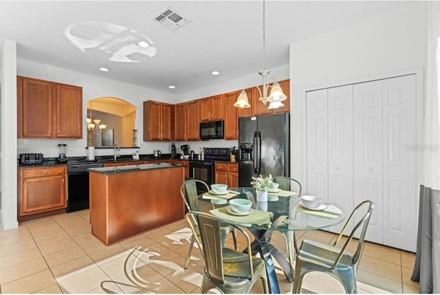 kitchen featuring light tile patterned floors, sink, pendant lighting, a kitchen island, and black appliances