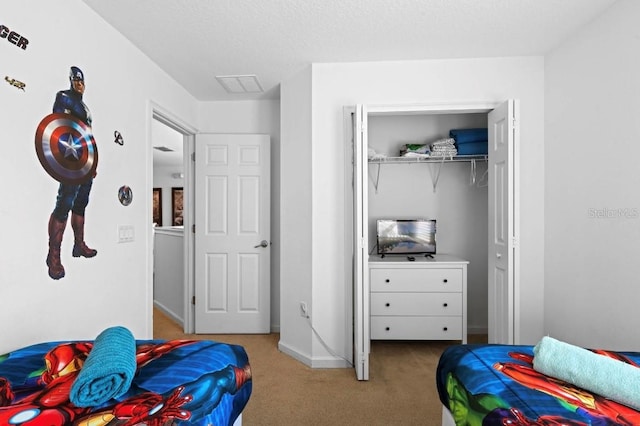 bedroom featuring a closet, a textured ceiling, and light colored carpet