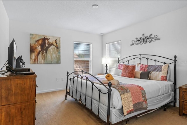 bedroom with a textured ceiling and light colored carpet