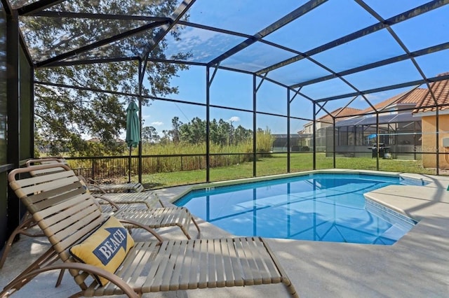 view of swimming pool featuring a lawn, a patio area, and glass enclosure