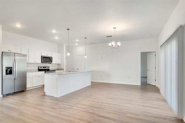 kitchen featuring a kitchen island with sink, decorative light fixtures, stainless steel appliances, and white cabinets