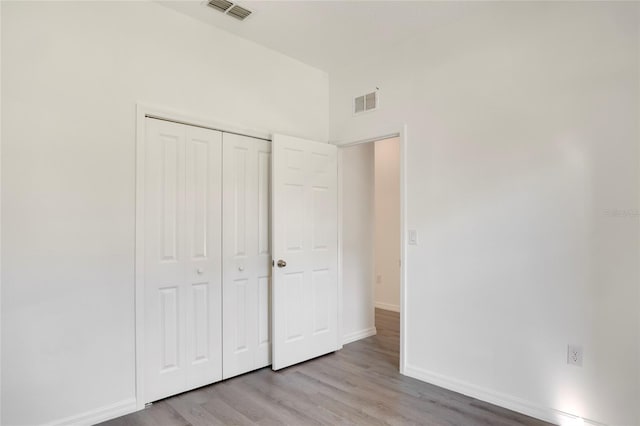 unfurnished bedroom with a closet and light hardwood / wood-style flooring