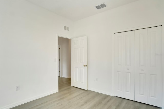 unfurnished bedroom featuring a closet and light hardwood / wood-style flooring