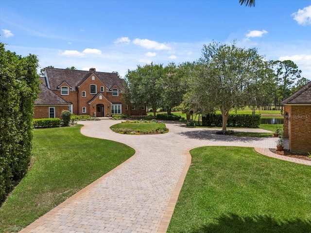 exterior space with curved driveway and a yard