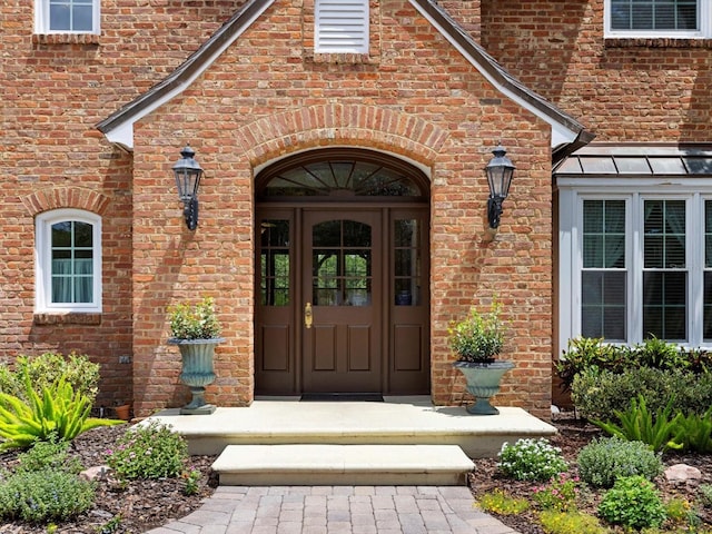 property entrance with brick siding and visible vents