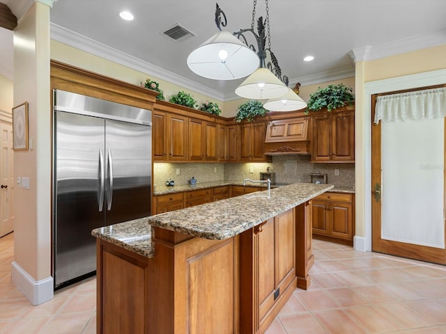 kitchen featuring ornamental molding, brown cabinets, visible vents, and built in refrigerator