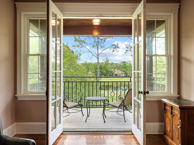 doorway to outside featuring french doors, wood finished floors, and baseboards