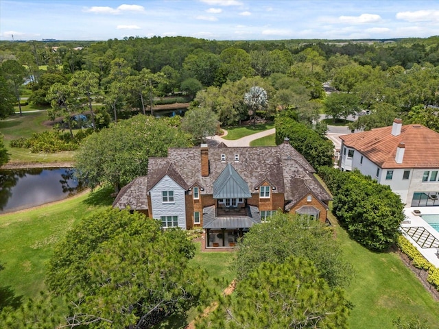 drone / aerial view with a water view and a forest view