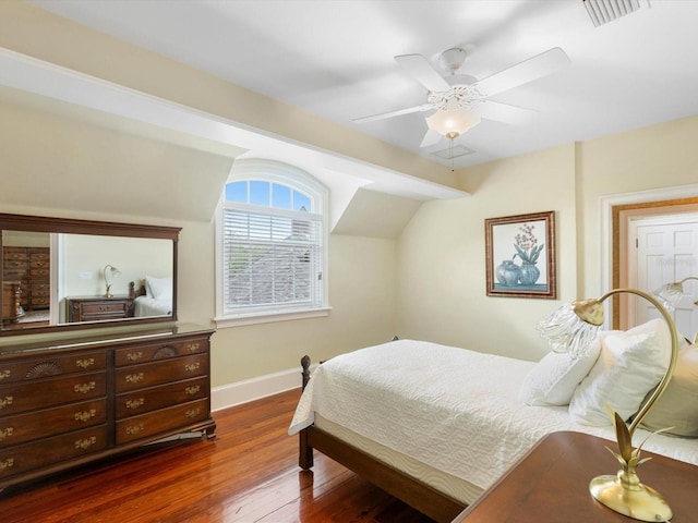 bedroom featuring visible vents, dark wood-type flooring, a ceiling fan, vaulted ceiling, and baseboards