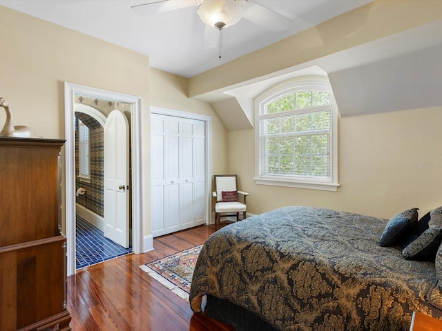 bedroom with ceiling fan, a closet, vaulted ceiling, and wood finished floors