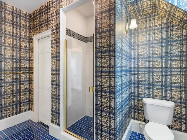 bathroom with a shower stall, toilet, and tile patterned floors