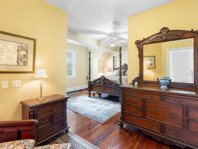 bedroom with dark wood-style floors, visible vents, and baseboards