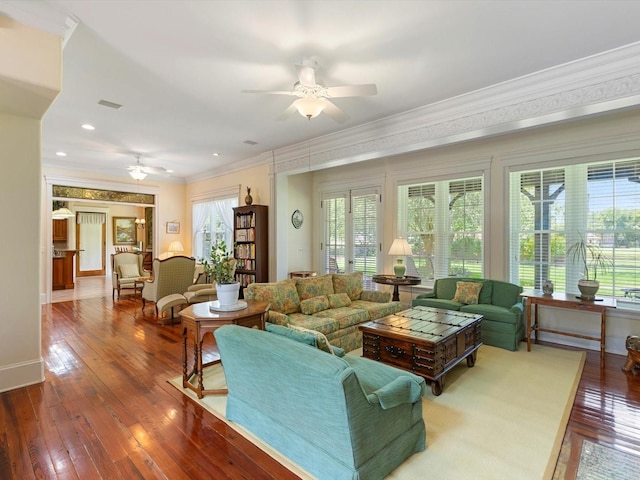 living area with crown molding, wood-type flooring, and plenty of natural light